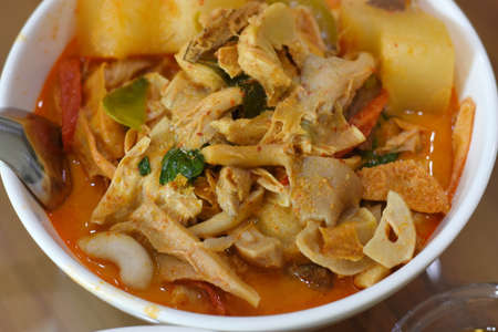 Thai spicy soup with pork and vegetables in white bowl on tableの写真素材