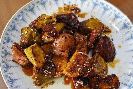 Roasted potatoes with honey and sesame seeds in a plate.