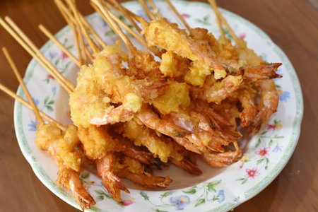 Fried prawns on wooden sticks, Thai style food.