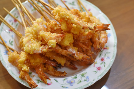 Fried prawns on skewers on a plate.
