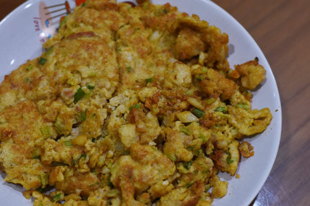 Crispy fried cauliflower with green onion on a white plate