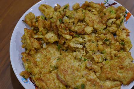 Crispy fried cauliflower with green onions on a white plateの写真素材