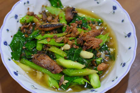 Stir-fried Chinese kale with pork in a bowlの写真素材