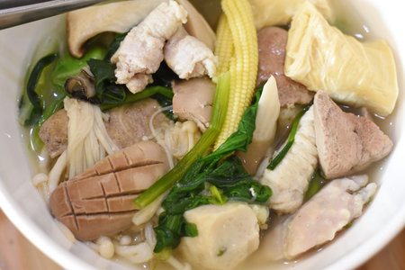 Thai noodle soup with pork, chicken and vegetable in bowl
