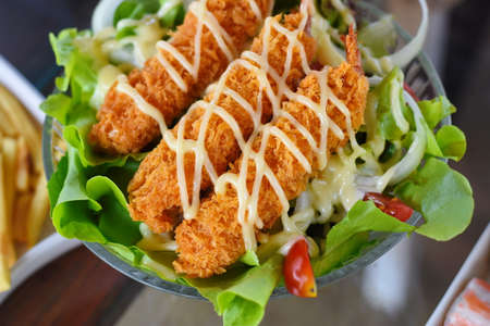 Crispy fried chicken with salad on the tableの写真素材