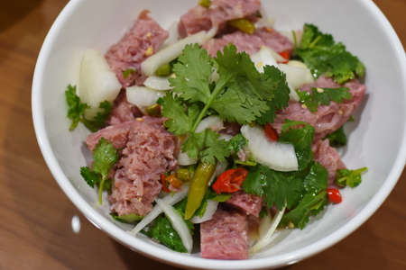 Pork salad with coriander and chilli in a white bowlの写真素材
