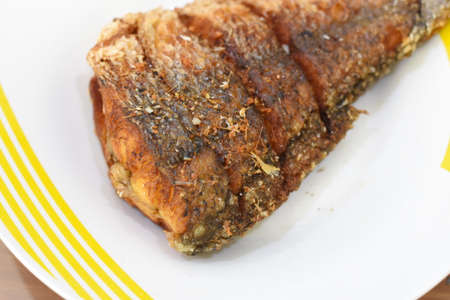 Fried fish with spices on a plate. Close-up.の写真素材