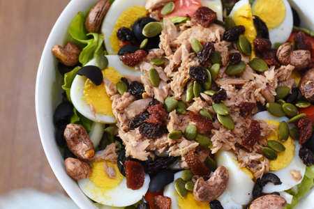 Tuna salad with quail eggs, raisins and pumpkin seedsの写真素材