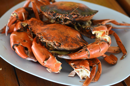 Steamed crabs on a plate on a wooden table, close-upの写真素材