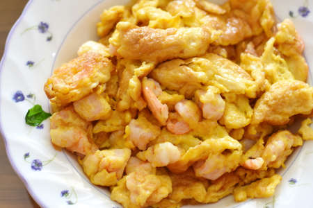 Fried shrimp with scrambled eggs on a plate. Close-up.の写真素材
