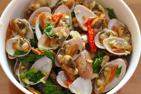 Stir-fried clams with garlic and chili in white bowlの写真素材