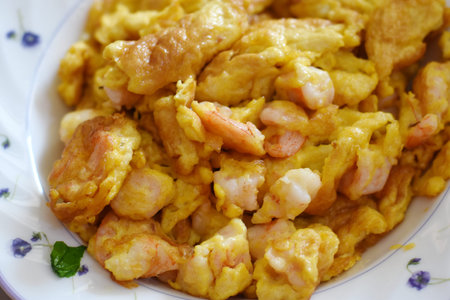 Scrambled eggs with shrimps on a plate, close upの写真素材