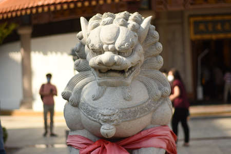 Statue of a lion at the entrance to the Buddhist temple.の写真素材