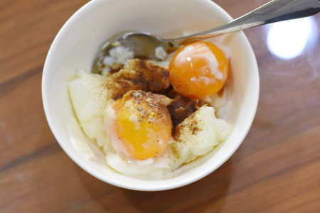 Fried egg in a white bowl on wooden table.の写真素材