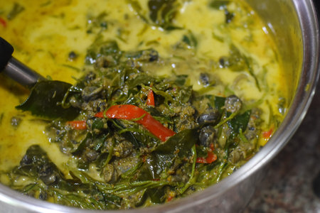 Stir-fried spinach with egg and chili in a pan.