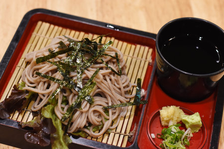 Soba noodles with seaweed and soy sauce on a wooden table