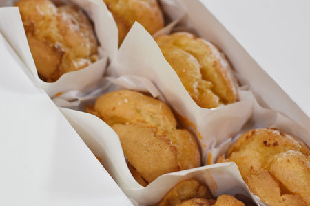 Close up of fresh baked butter cookies in paper box on white background