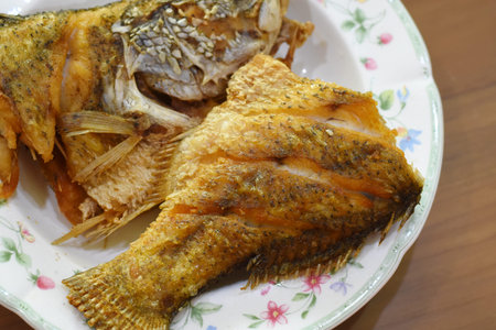 Fried fish with salt and pepper in a plate on the table