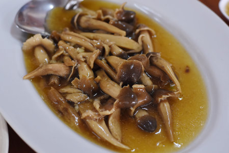 Mushroom soup in white dish with spoon on wooden table.