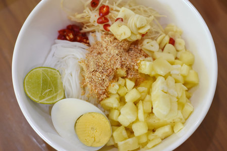 Thai noodle soup with pork and egg on wooden table.の写真素材