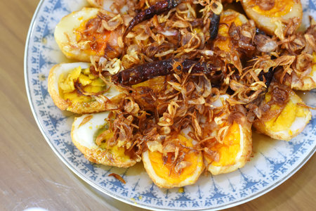 Fried eggs with fried onions in a plate on the table
