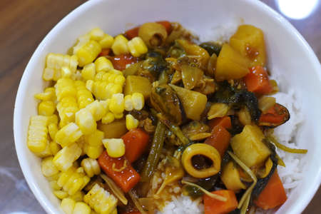 Rice with stir-fried vegetables and sweet corn in a bowlの写真素材