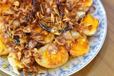 Fried egg yolk with crispy pork, Thai style food.