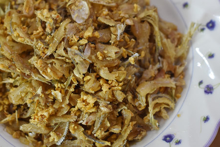 Fried fish with garlic and salt in a white plate on the table