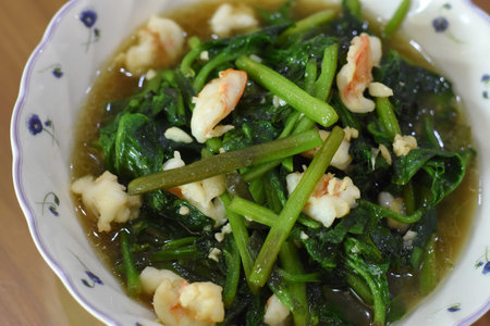 Stir-fried Chinese kale with shrimp and garlic in a bowlの写真素材