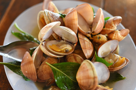 Steamed clams with garlic on white plate, Thai food.