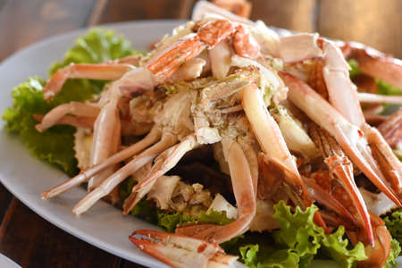 Steamed crab with fresh vegetables on white plate.の写真素材