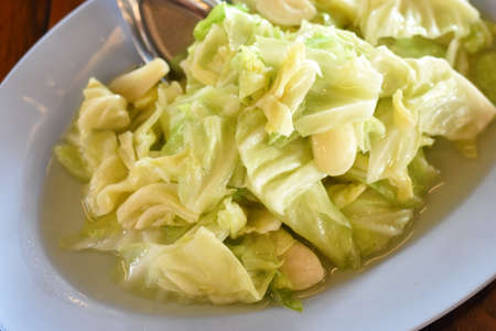 cabbage salad on white dish with spoon on wooden table, stock photoの写真素材