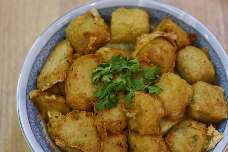 fried potatoes in a blue bowl on a wooden table with parsley