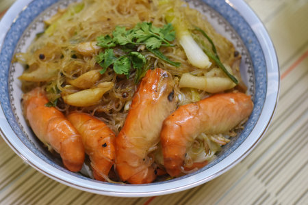 Rice noodles with shrimps and vegetables in a bowl.