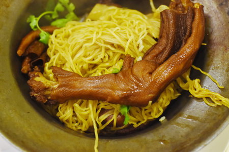 Chinese noodle with pork and egg yolk in ceramic bowl.の写真素材
