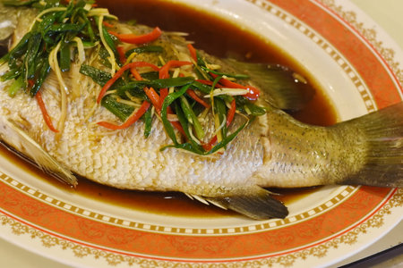 Steamed fish with chili and soy sauce in a restaurant in Thailandの写真素材