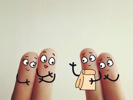 Four fingers are decorated as four person. Two of them is sending a parcel their friends.の写真素材