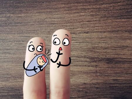Two fingers are decorated as two person. One of them is holding a baby with fever.の写真素材