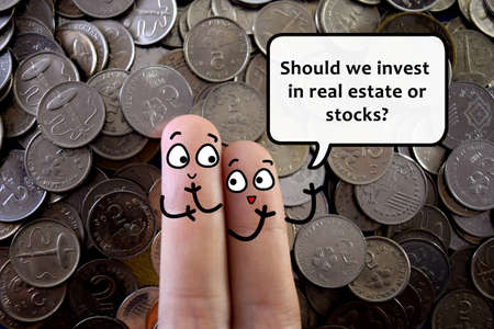 Two fingers are decorated as two person. They are discussing about investing in real estate or stock.の写真素材