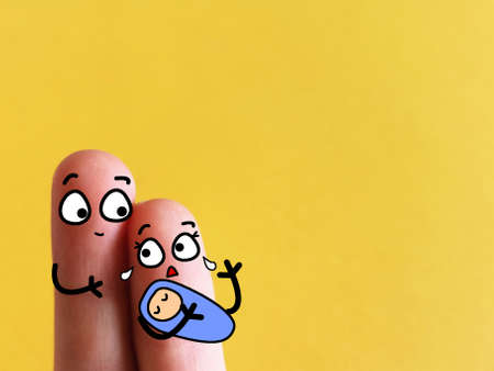 Two fingers are decorated as a couple holding a cute baby. The mother is suffering from postpartum depression.の写真素材