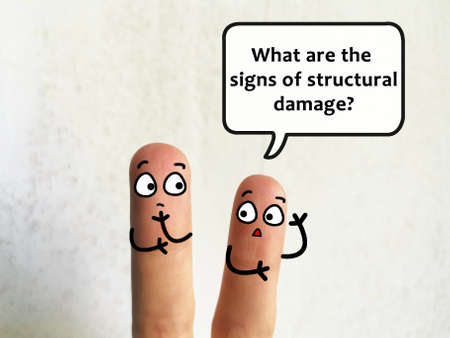 Two fingers are decorated as two person. They are discussing about problems of building. One of them is asking about signs of structural damage.の写真素材