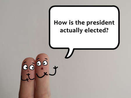 Two fingers are decorated as two person. They are discussing about election. One of them is curious about how the president is elected and how the election actually works.の写真素材