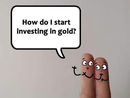 Two fingers are decorated as two person. They are discussing how to start investing in gold.の写真素材