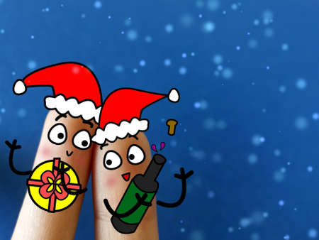 Two fingers are decorated as two person. They are celebrating christmas in snow.の写真素材
