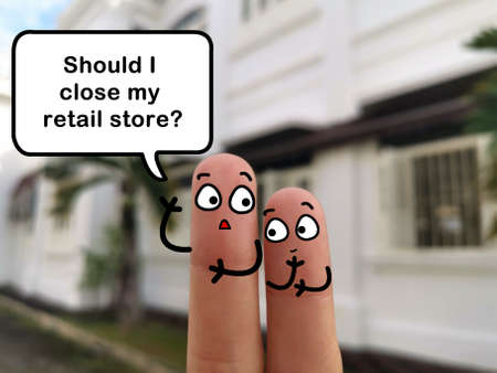 Two fingers are decorated as two person. They are discussing about closing retail store.の写真素材