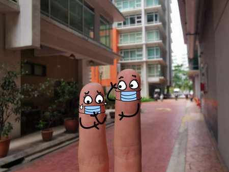 Two fingers are decorated as two person. One of them is suffering from depression after coronavirus outbreak.の写真素材