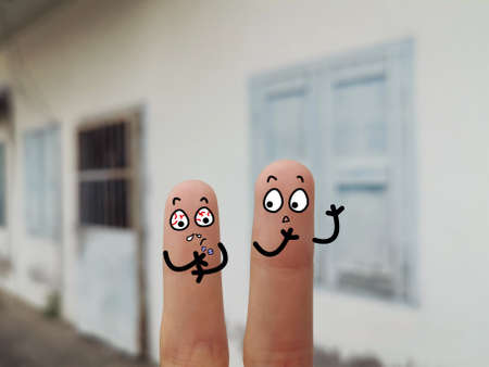 Two fingers are decorated as two person. They are at the back yard. One of them is having withdrawal symptom.の写真素材