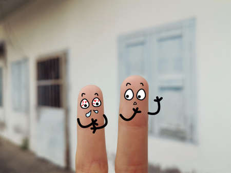 Two fingers are decorated as two person. They are at the back yard. One of them is having flu.の写真素材