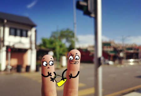 Two fingers are decorated as two person. One of them is a bad guy he is snatching a bag.の写真素材