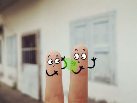 Two fingers are decorated as two person. They are at the back yard. One of them is having bad breath.の写真素材